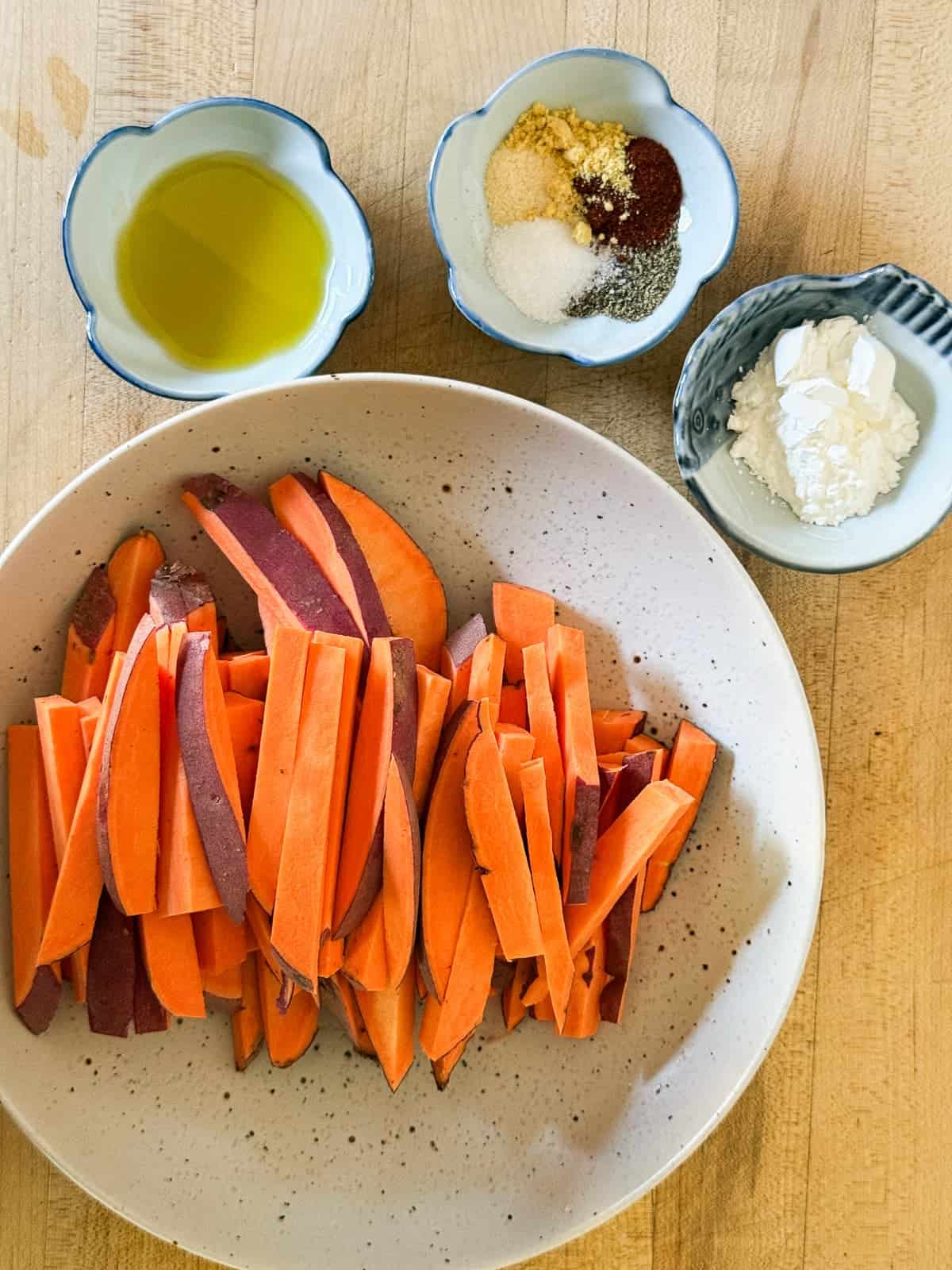 ingredients for sweet potato fries. sliced sweet potatoes, cornstartch, olive oil, and spices