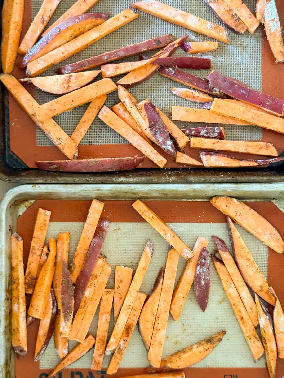 sweet potato fries spread out on two baking sheets